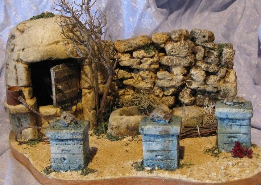 3 ruches devant un puits en forme de borie accollé à un mur en pierres sèches
